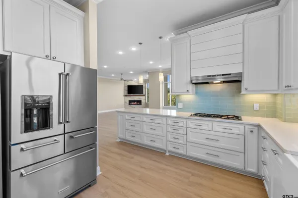 a kitchen with stainless steel appliances granite countertop a refrigerator and a stove top oven