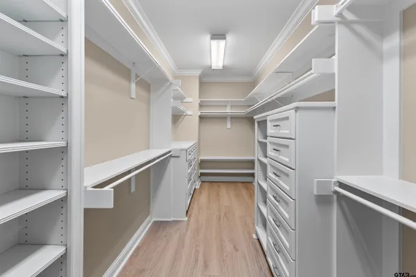 a view of walk in closet with empty racks