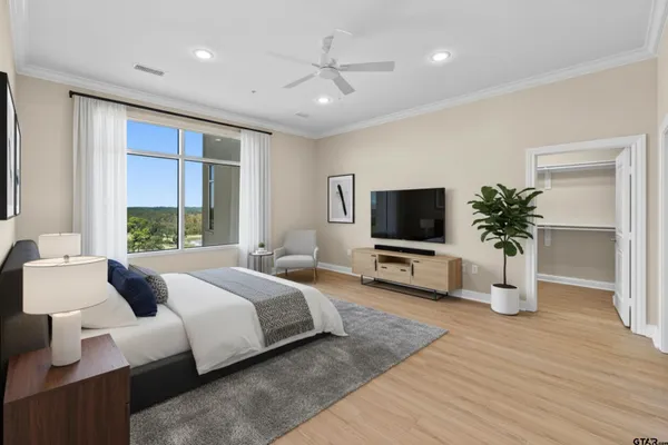a bedroom with a bed a flat screen tv and a couch