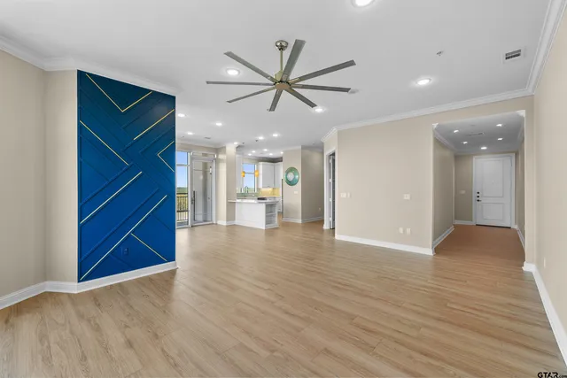 a view of a livingroom with a ceiling fan wooden floor and window