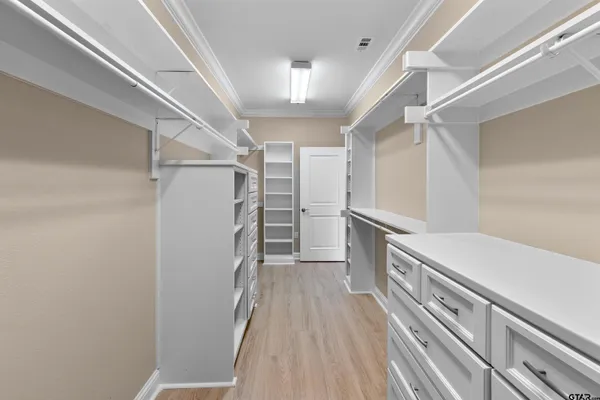 a view of walk in closet with wooden floor and staircase