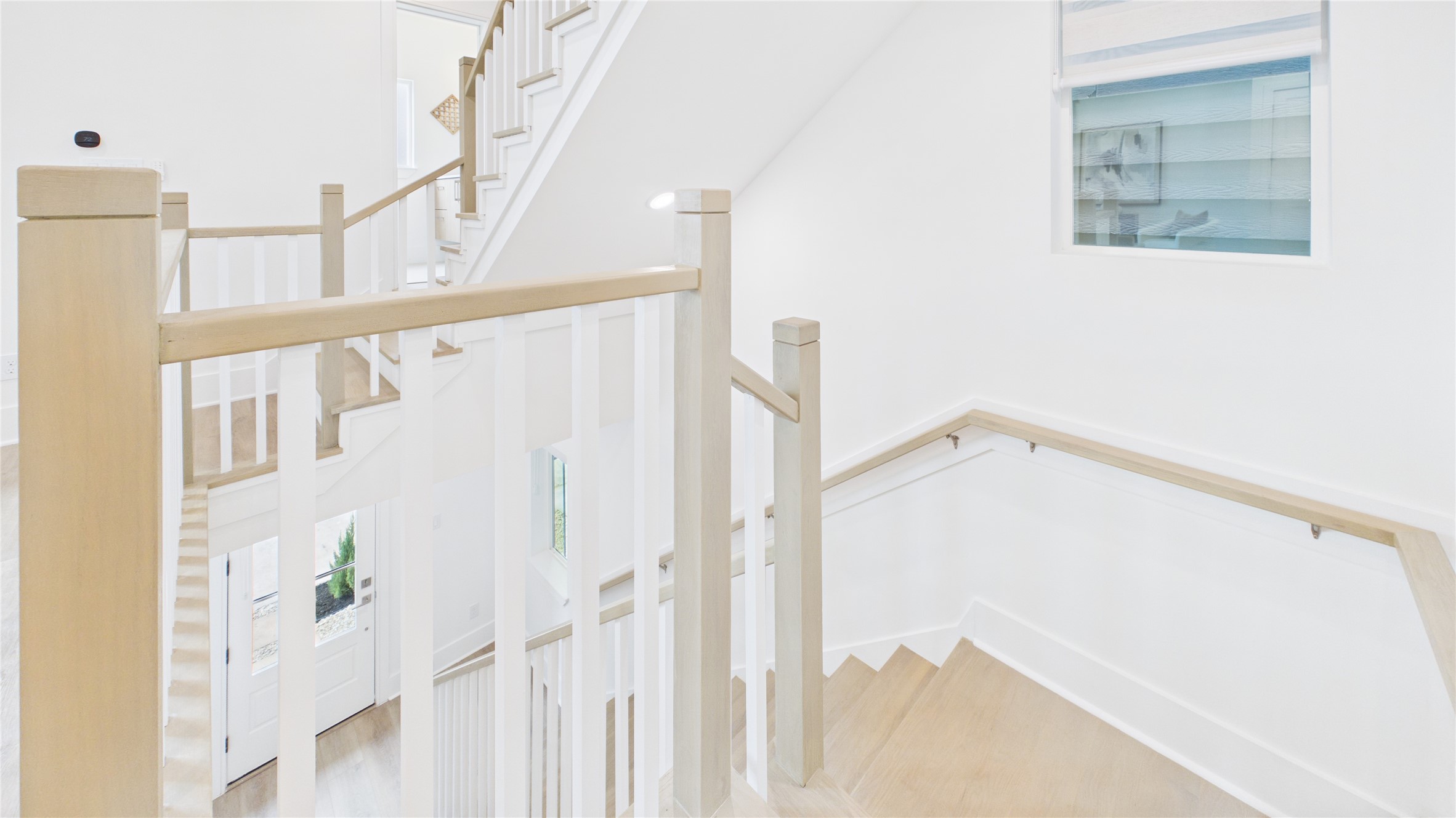 602 Skyland Terrace Way Houston, TX 77009 - Photo 34 of 40 This photo showcases a bright, modern staircase with light wood railings and white accents. The space is well-lit with natural light from a window, creating an open and airy feel.
