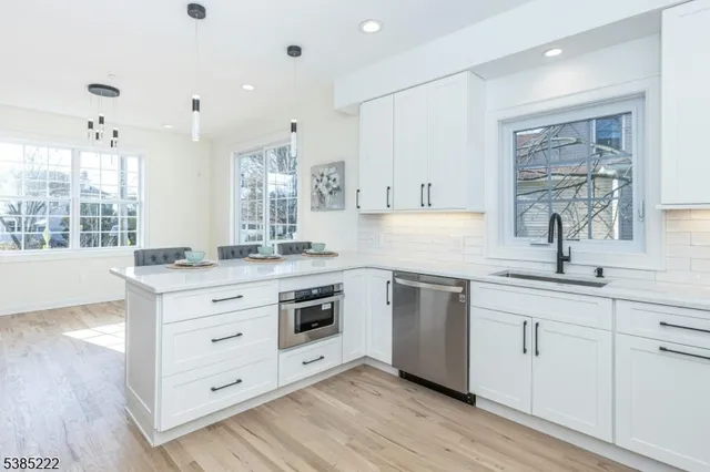 a kitchen with granite countertop white cabinets and white appliances
