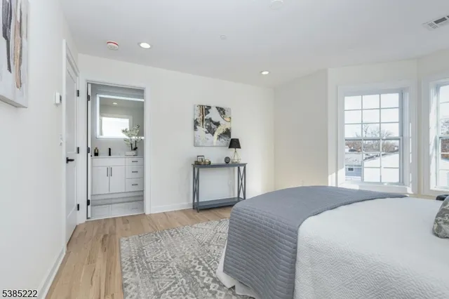 a bedroom with a large bed and a chandelier