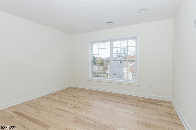 484 4th Avenue, Unit 9 Garwood, NJ 07027 - Photo 21 of 28 an empty room with wooden floor and windows