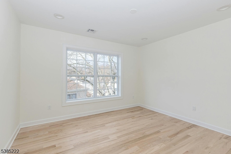 484 4th Avenue, Unit 9 Garwood, NJ 07027 - Photo 23 of 28 an empty room with wooden floor and windows