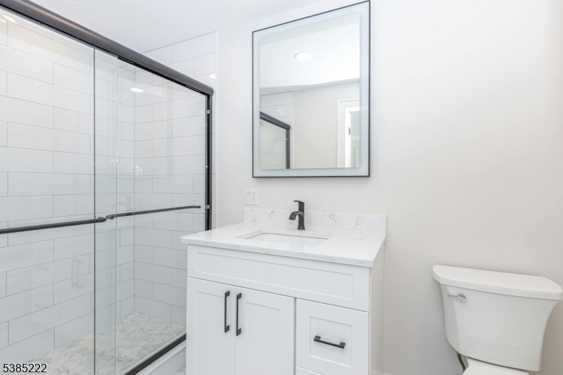 484 4th Avenue, Unit 9 Garwood, NJ 07027 - Photo 26 of 28 a bathroom with a sink a toilet and a mirror
