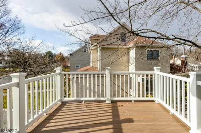 a view of a house with a small yard and wooden floor and fence