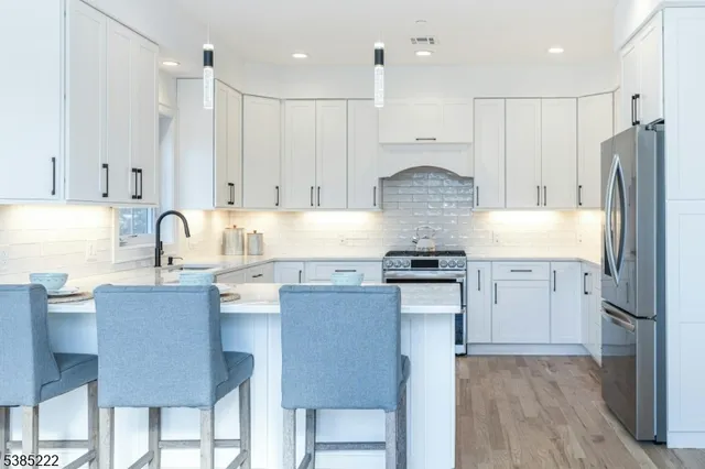 a kitchen with stainless steel appliances granite countertop a stove refrigerator sink and cabinets