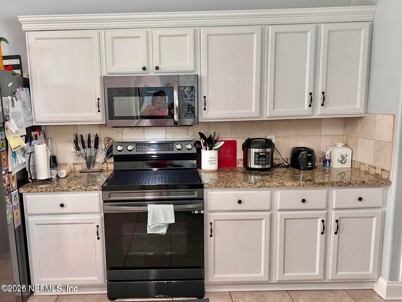 3419 Bristol Bridge Road Orange Park, FL 32073 - Photo 11 of 36 a kitchen with white cabinets and appliances