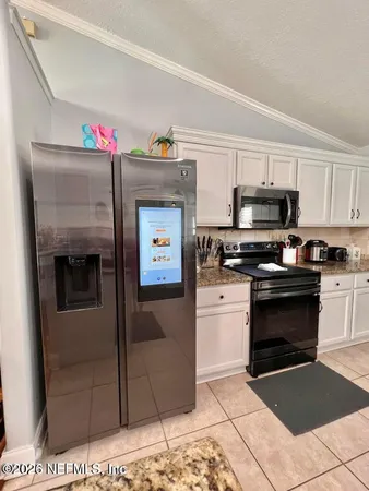 a kitchen with granite countertop a stove top oven and cabinets