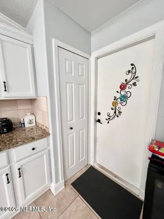 a very nice looking open white kitchen with granite countertop a sink