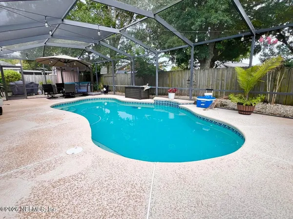 a view of a swimming pool with a patio and a garden