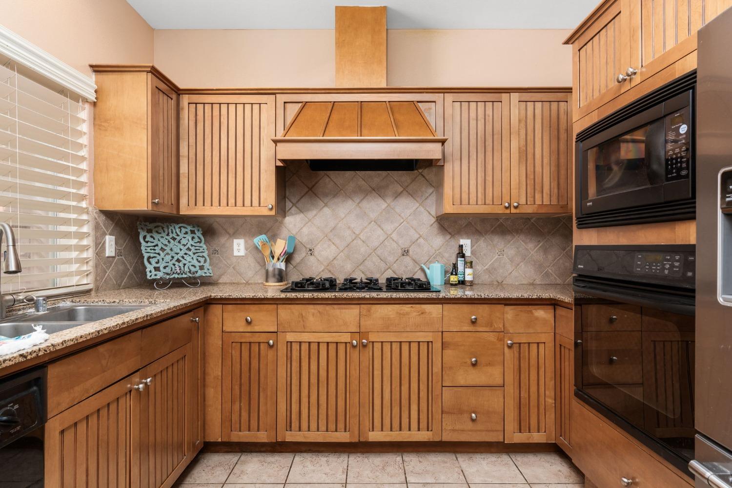 2763 Pico Avenue Clovis, CA 93611 - Photo 11 of 27 a kitchen with stainless steel appliances granite countertop a stove and a sink