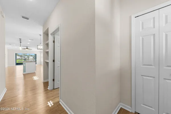 a view of a hallway with wooden floor windows and a kitchen