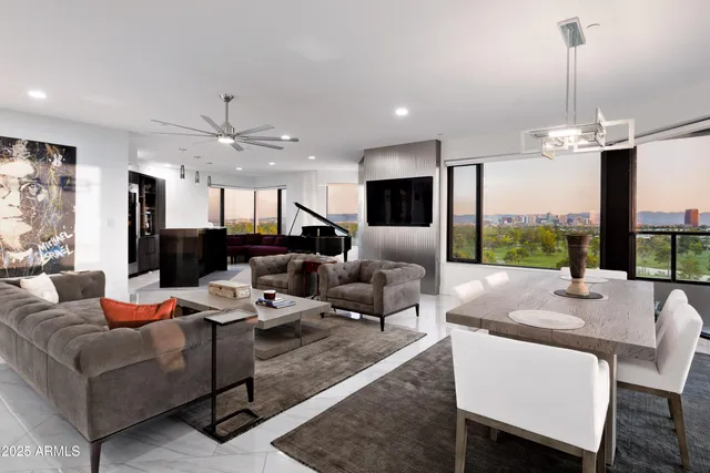 a living room with furniture kitchen view and a large window