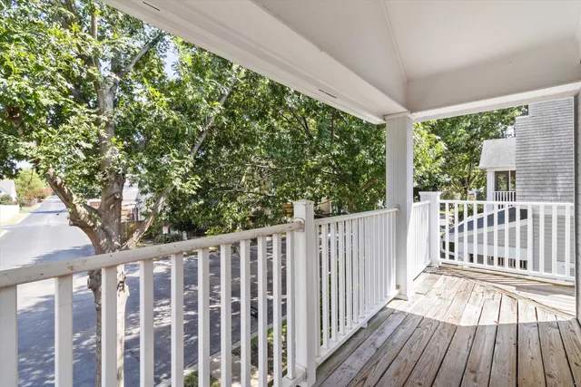 a view of a wooden deck and a yard with wooden fence