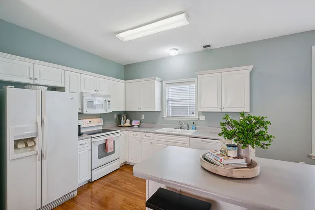 a kitchen with a white refrigerator and cabinets