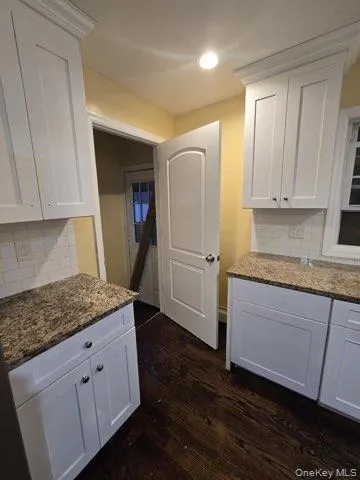 a kitchen with granite countertop wooden cabinets and white appliances