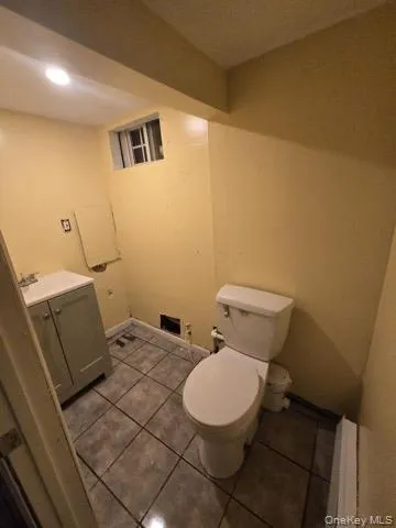 a white toilet sitting next to a white sink and vanity