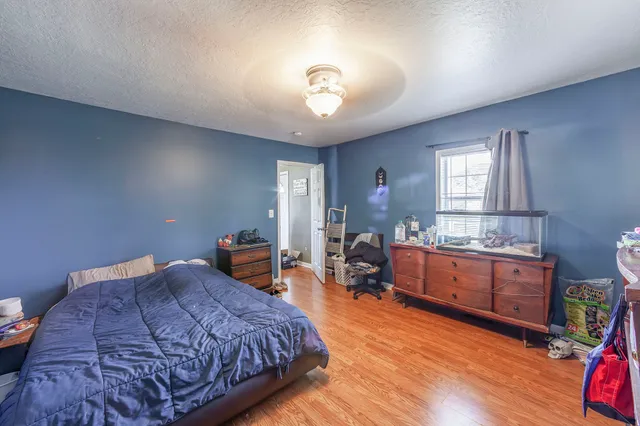 a bedroom with a bed and wooden floor