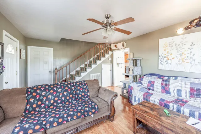 a kitchen with stainless steel appliances granite countertop a refrigerator a sink dishwasher a stove top oven a refrigerator with white cabinets and wooden floor