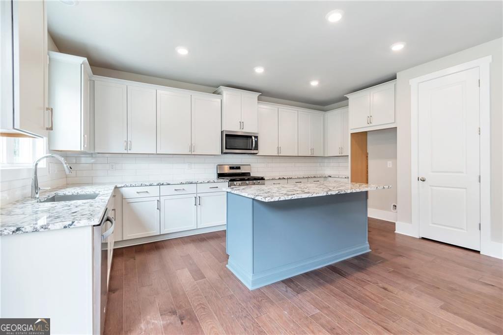 333 Willow Cove Canton, GA 30114 - Photo 11 of 37 a kitchen with granite countertop white cabinets and black stainless steel appliances