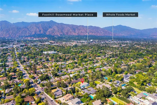 an aerial view of residential house with yard and mountain view in back