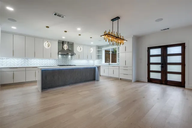 a view of a kitchen with a sink and dishwasher with wooden floor