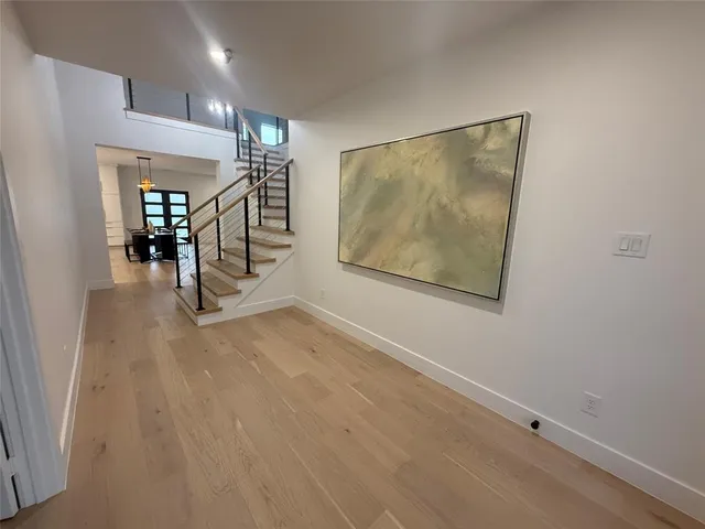 en empty room with stairs and wooden floor