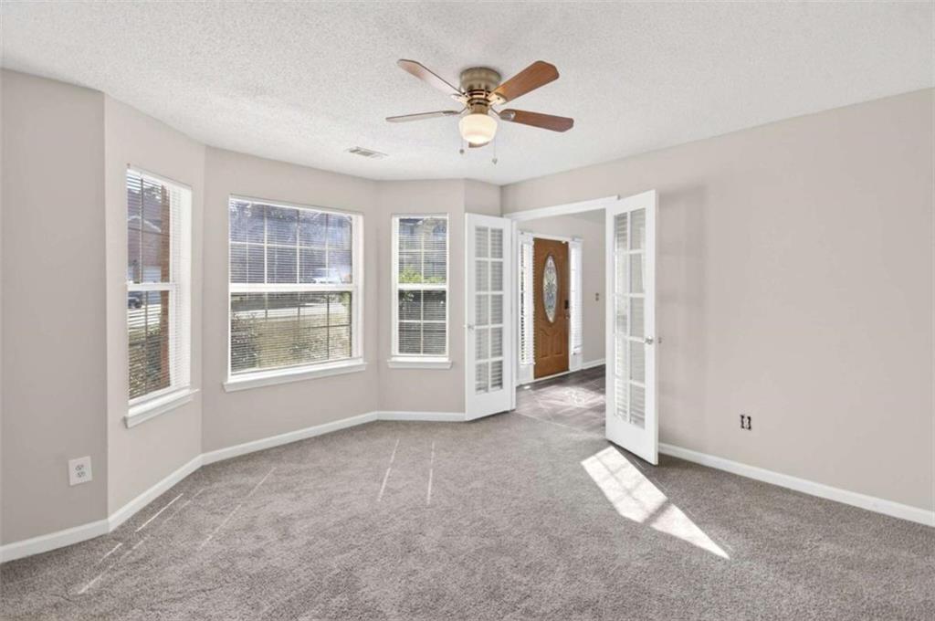 1727 Rice Square Lithonia, GA 30058 - Photo 11 of 33 an empty room with chandelier fan and windows
