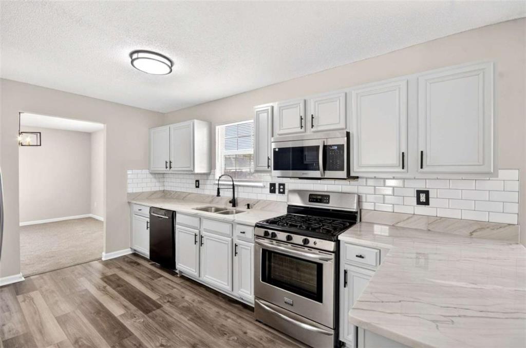 1727 Rice Square Lithonia, GA 30058 - Photo 5 of 33 a kitchen with granite countertop a sink cabinets and stainless steel appliances