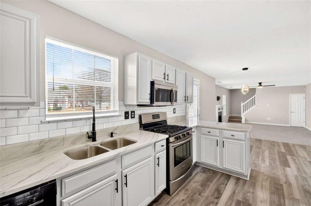 1727 Rice Square Lithonia, GA 30058 - Photo 6 of 33 a kitchen with a sink white cabinets and appliances