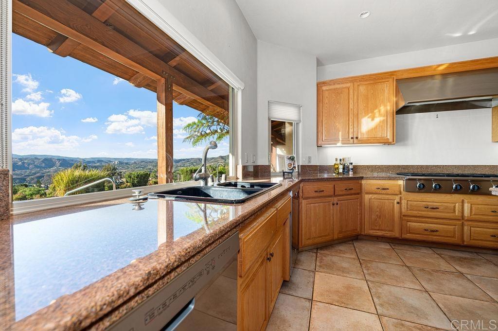 2155 Mil Sorpresas Drive Fallbrook, CA 92028 - Photo 19 of 48 a kitchen with a sink window and cabinets