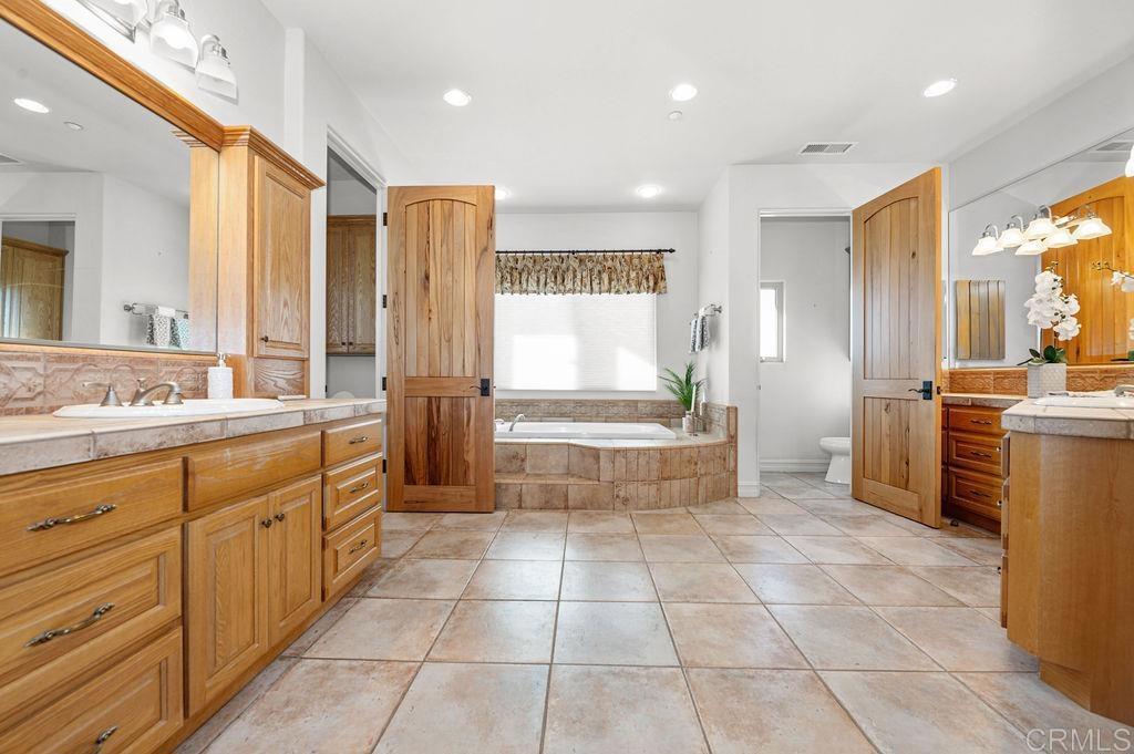 2155 Mil Sorpresas Drive Fallbrook, CA 92028 - Photo 24 of 48 a bathroom with a sink a mirror and a bathtub