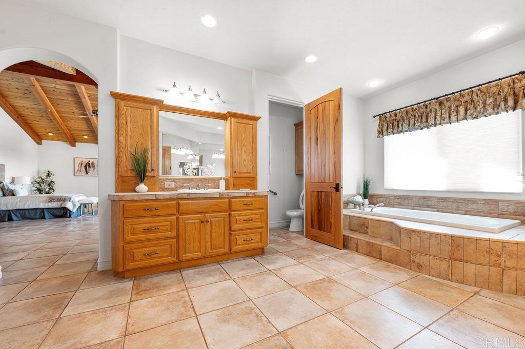 2155 Mil Sorpresas Drive Fallbrook, CA 92028 - Photo 26 of 48 a large bathroom with a large tub sink and mirror