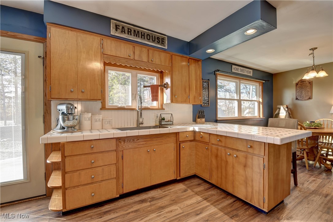 15235 Stocker Ridge Road Southwest Newcomerstown, OH 43832 - Photo 20 of 37 Kitchen featuring light hardwood / wood-style flooring, tile counters, and kitchen peninsula