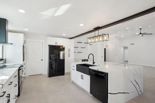 a large white kitchen with a sink and refrigerator