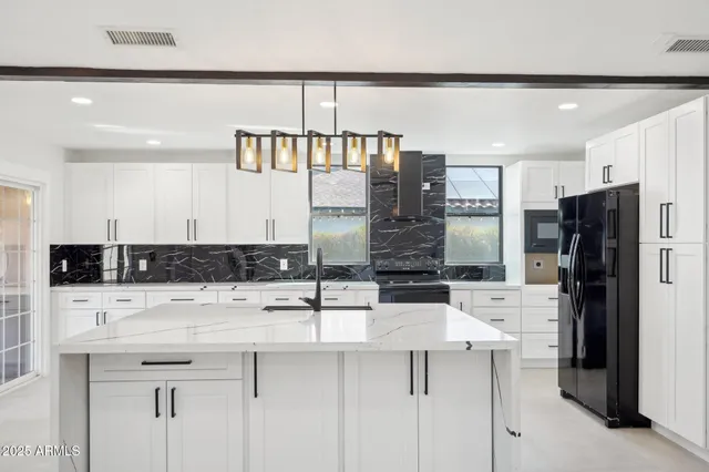 a kitchen with stainless steel appliances a sink and a refrigerator