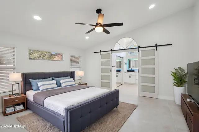 a bedroom with a large bed and a chandelier