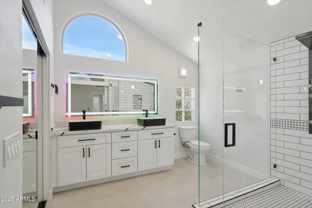 a bathroom with a double vanity sink a mirror and shower