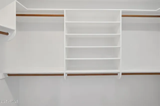 a view of walk in closet with empty racks