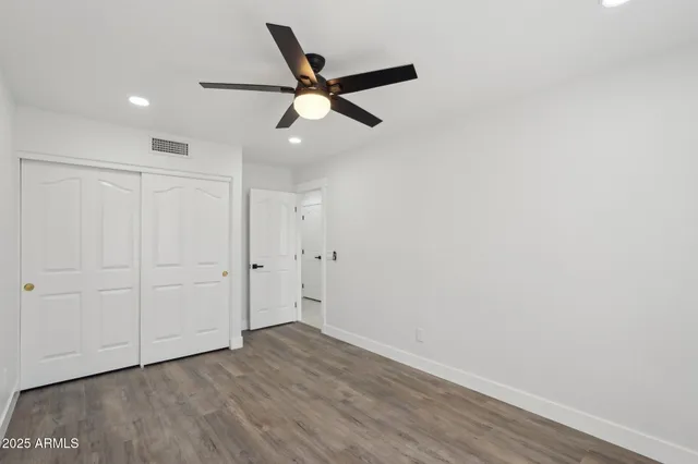 a view of a room with wooden floor and ceiling fan