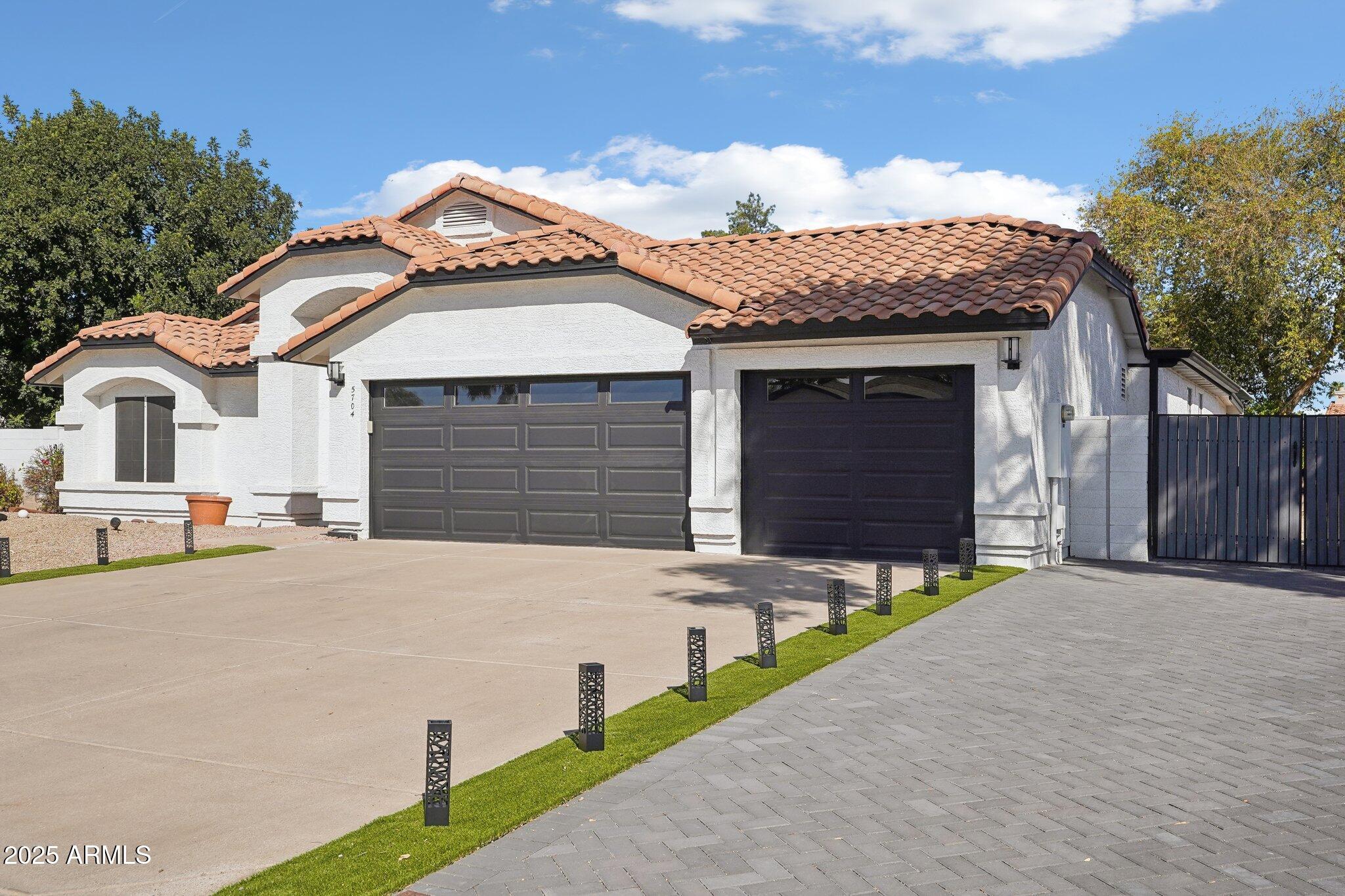 5704 East Estrid Avenue Scottsdale, AZ 85254 - Photo 36 of 48 a front view of a house with a yard and garage