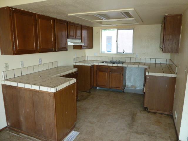 77 Overpass Road, Unit B Watsonville, CA 95076 - Photo 2 of 10 a kitchen with stainless steel appliances granite countertop wooden cabinets a sink and a stove