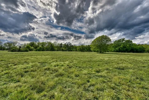 a view of a green field with wooden fence
