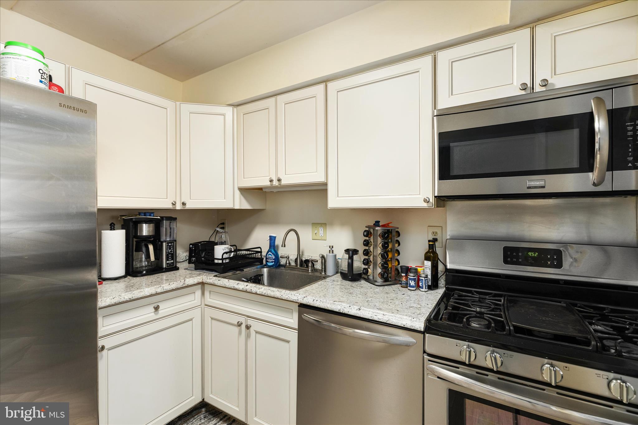 125 Clubhouse Drive Southwest, Unit 1 Leesburg, VA 20175 - Photo 5 of 17 a kitchen with stainless steel appliances granite countertop white cabinets and a stove top oven