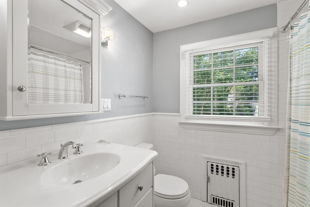 513 Chestnut Street Newton, MA 02468 - Photo 17 of 32 a bathroom with a toilet a sink a mirror and a window