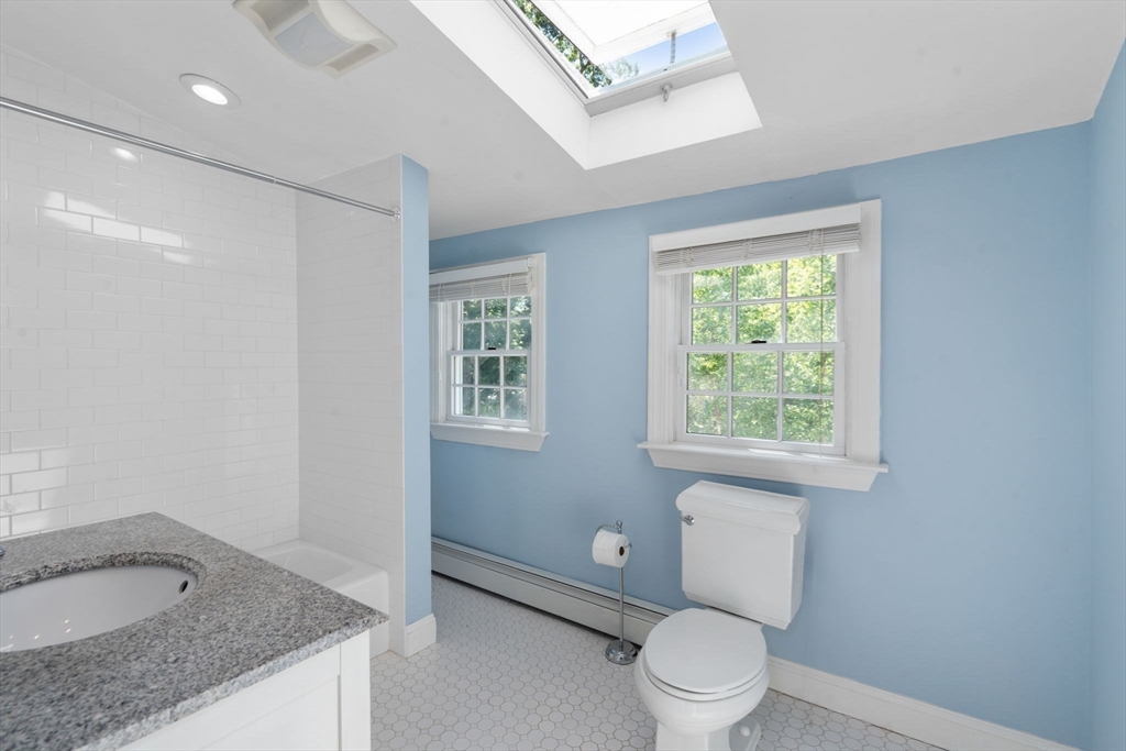 513 Chestnut Street Newton, MA 02468 - Photo 18 of 32 a bathroom with a granite countertop sink a toilet and a window