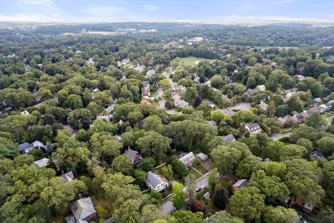 an aerial view of a houses with a green hillside